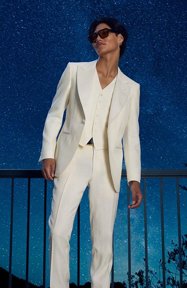 man wearing white suit with stars in background