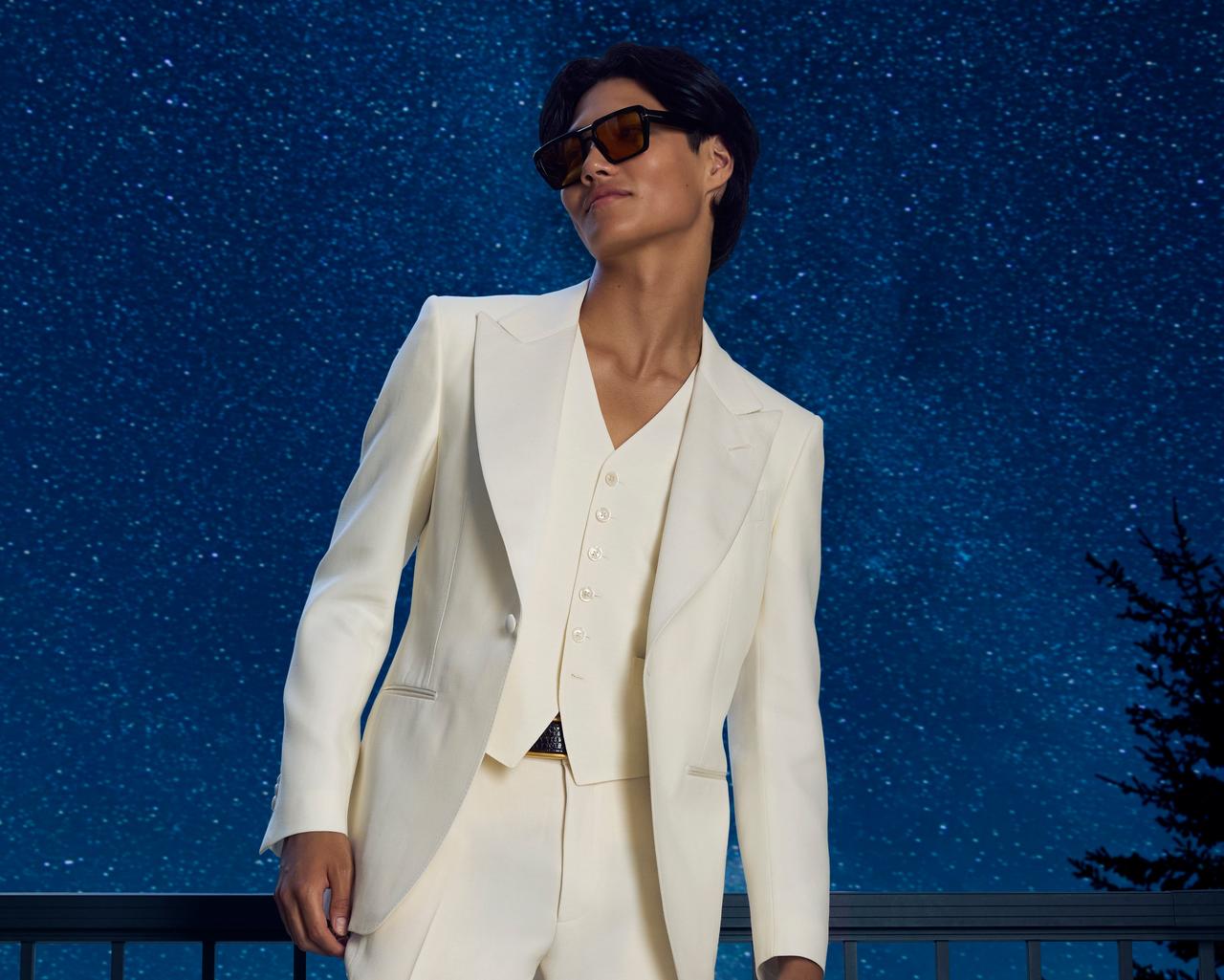 man wearing white suit with stars in background