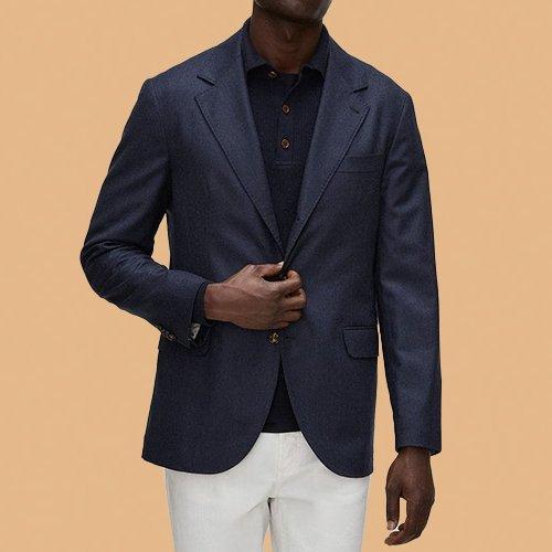 male model wearing sport jacket on orange backdrop