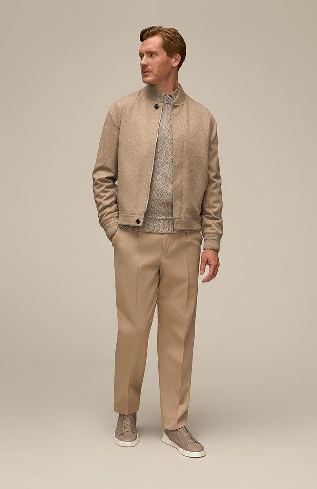 A man wearing tan suit and sneakers dresssed for the office in business casual clothing