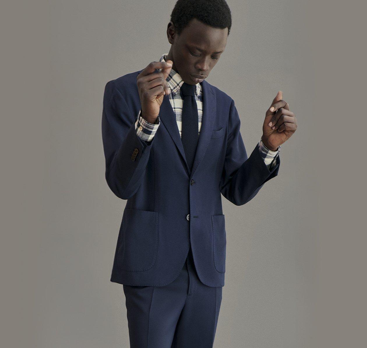 A man wearing a navy blue BOGLIOLI suit with a tie