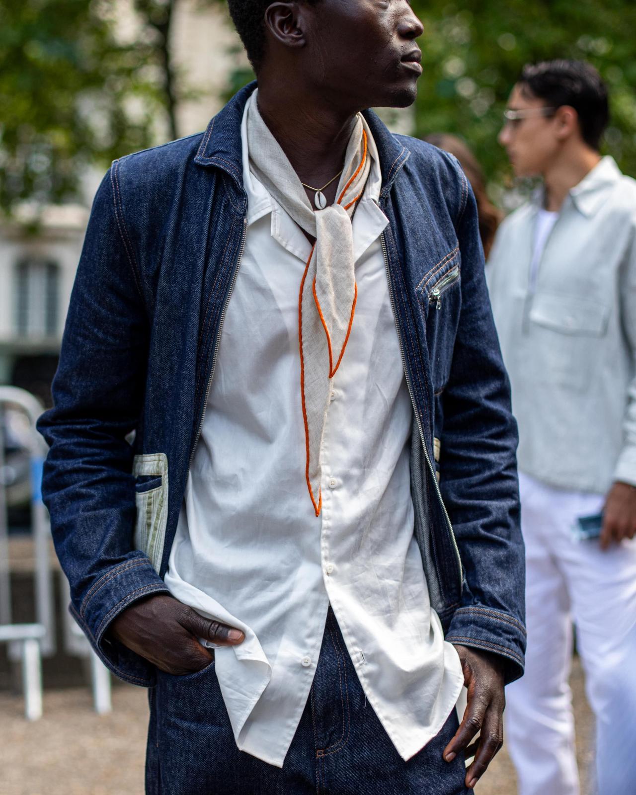 Man in dark denim jacket and jeans with white shirt and scarf