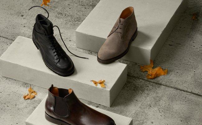 Three men's boots — black lace-up, taupe suede chukka, and burgundy Chelsea — displayed on concrete steps, Boots, FW26 Footwear collection
