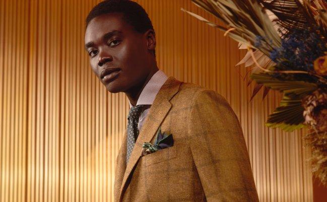 Mannequin portant une veste de costume beige à motif à carreaux, assortie à une cravate