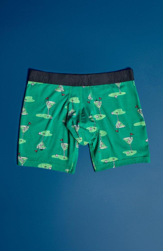 SAXX green boxer briefs featuring a black waistband and a golf-inspired print of martini glasses, golf balls, and flags