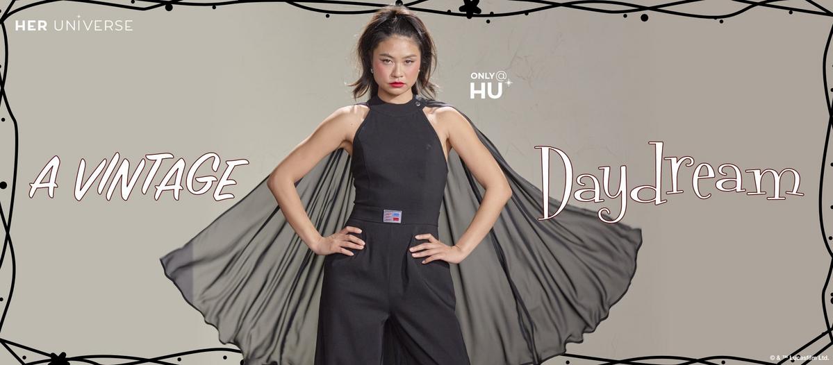 Woman wearing black jumpsuit with removable cape