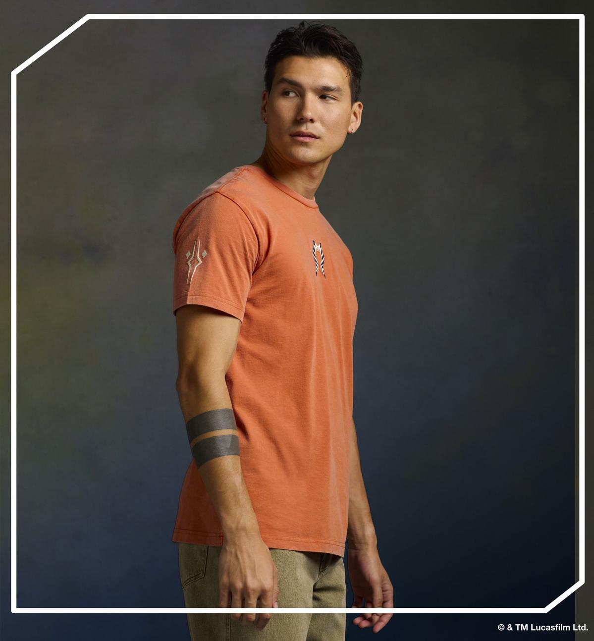 Man wearing orange t-shirt. Shop Our Universe