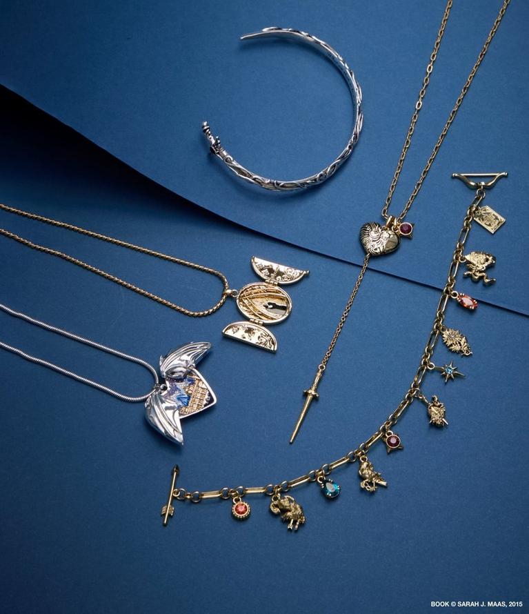 Assorted gold and silver jewelry including necklaces, charm bracelet, and cuff bracelet. Shop jewelry.