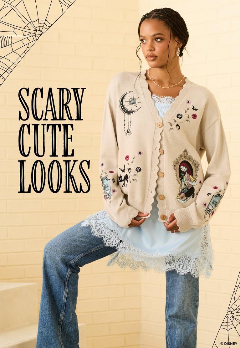 Model wearing Disney cardigan with spooky embroidered graphics and “SCARY CUTE LOOKS” text. Shop The Nightmare Before Christmas.