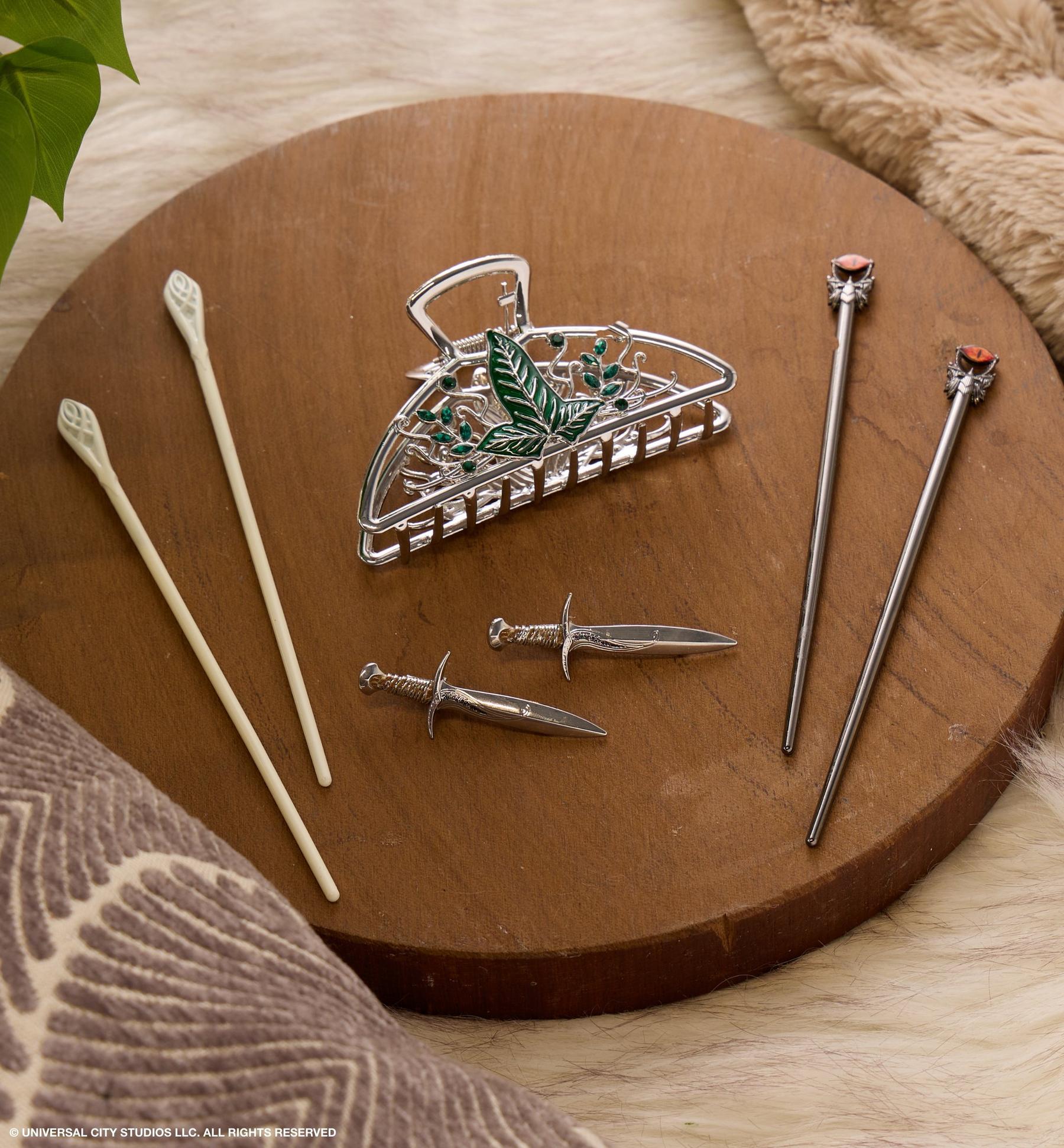 Silver leaf hair claw clip with assorted hair sticks and dagger-shaped hair pins. Shop hair accessories.