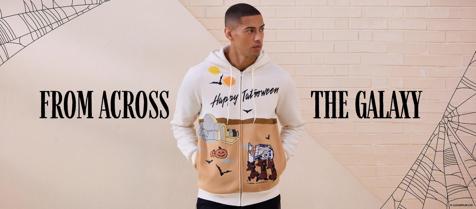 Model wearing a “Happy Tatooween” Star Wars hoodie with pumpkin and bat graphics. Shop Star Wars.