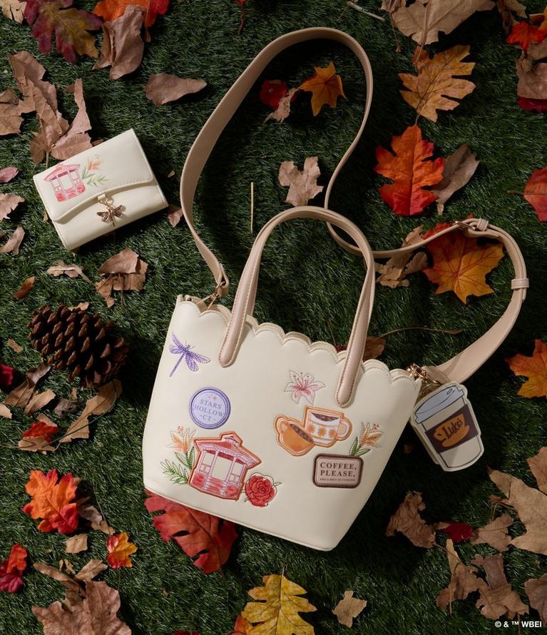 Cream tote bag with embroidered patches and matching wallet, shown with Luke’s cup charm. Shop bags.