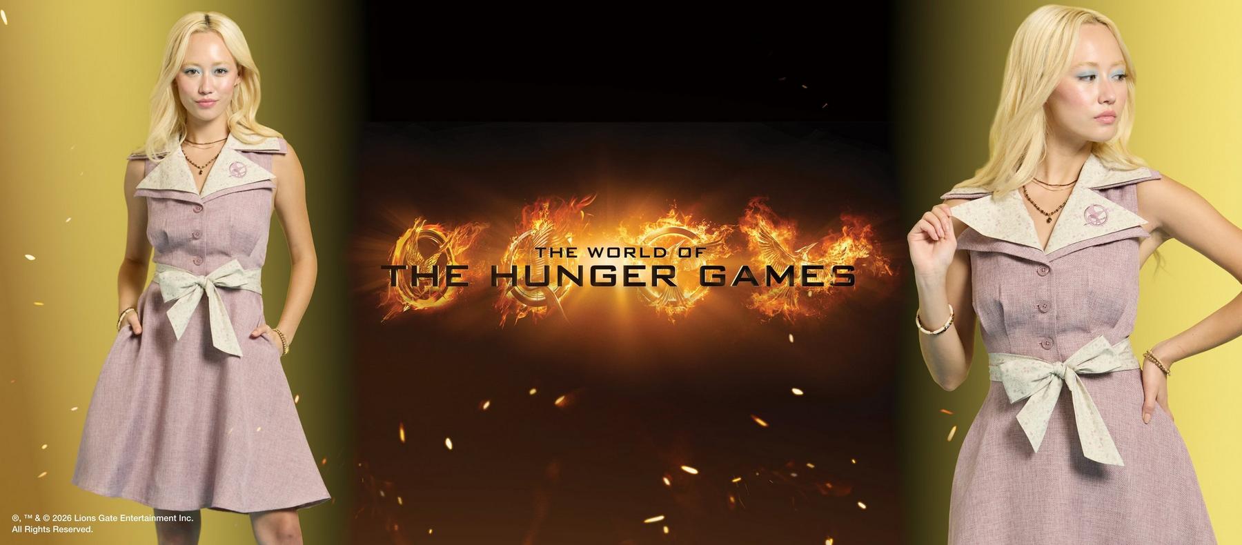 Woman modeling a sleeveless dress with bow belt and Hunger Games pin, beside “THE HUNGER GAMES” text. Shop The Hunger Games collection.