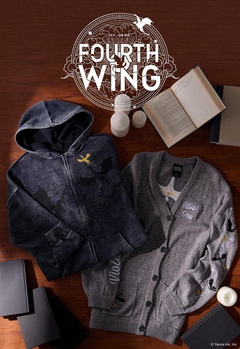 Fourth Wing hoodie and cardigan laid out with open books and candles. Shop Fourth Wing collection.