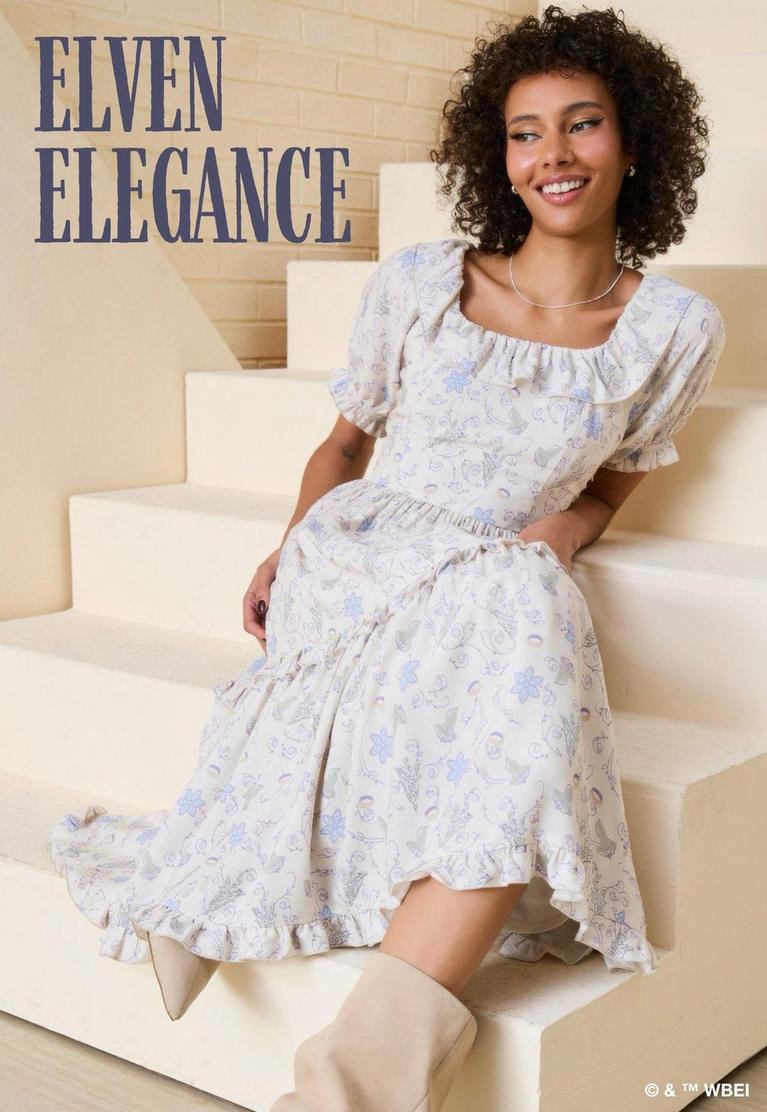 Model wearing a floral puff-sleeve midi dress and knee-high boots, seated on steps. Text: ELVEN ELEGANCE. Shop The Lord of the Rings.