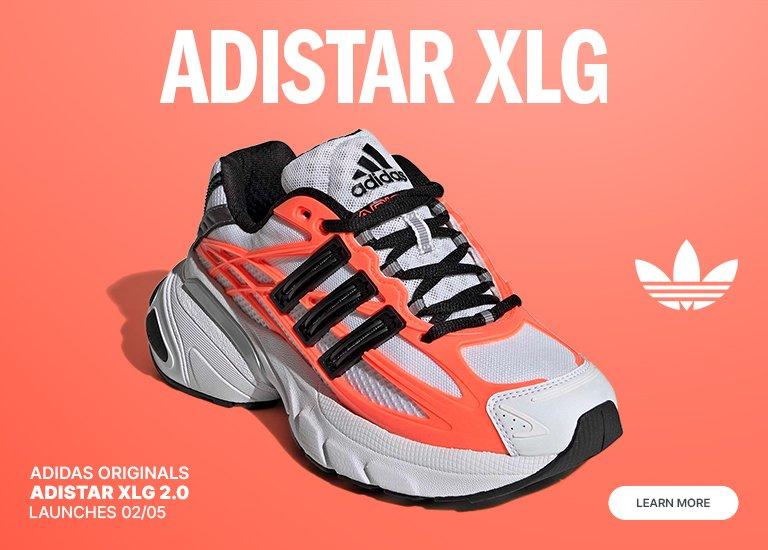 Promotional banner for the Adidas Originals Adistar XLG 2.0 sneaker, featuring a white and black shoe with vibrant orange accents on a coral background. Large white text at the top reads ADISTAR XLG, while the bottom-left indicates a launch date of 02/05. The Adidas Trefoil logo and a LEARN MORE button are also visible.