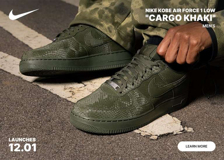 A promotional image for the Nike Kobe Air Force 1 Low Cargo Khaki men's shoe, featuring a close-up of the green, snakeskin-textured sneaker being worn with a matching camouflage outfit. The shoe includes Kobe Bryant's numbers 8 and 24 embossed on the heels. The image also states the launch date is 12.01.