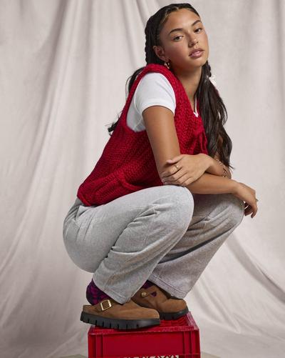 Young woman on top of red box in Birkenstocks