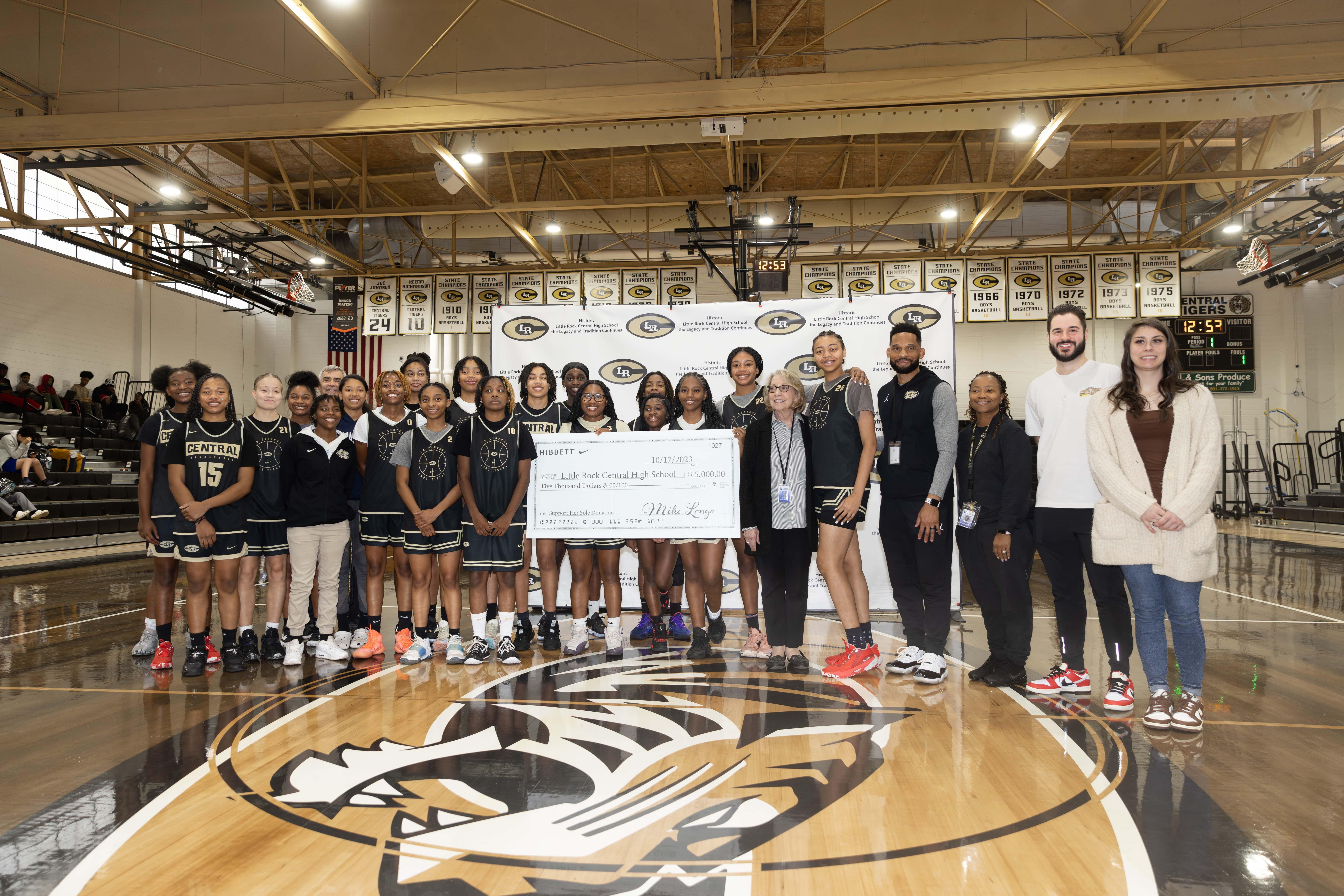 Group image of Little Rock Central High School Girls' basketball team and Hibbett reps with donation check