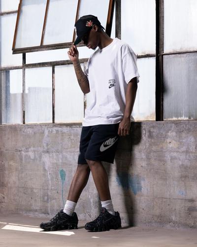 Man modeling white tee, black hat, black Nike shorts and Nike Shox TL "Black/MTLC Hematite/Max Orange" Men's Shoe