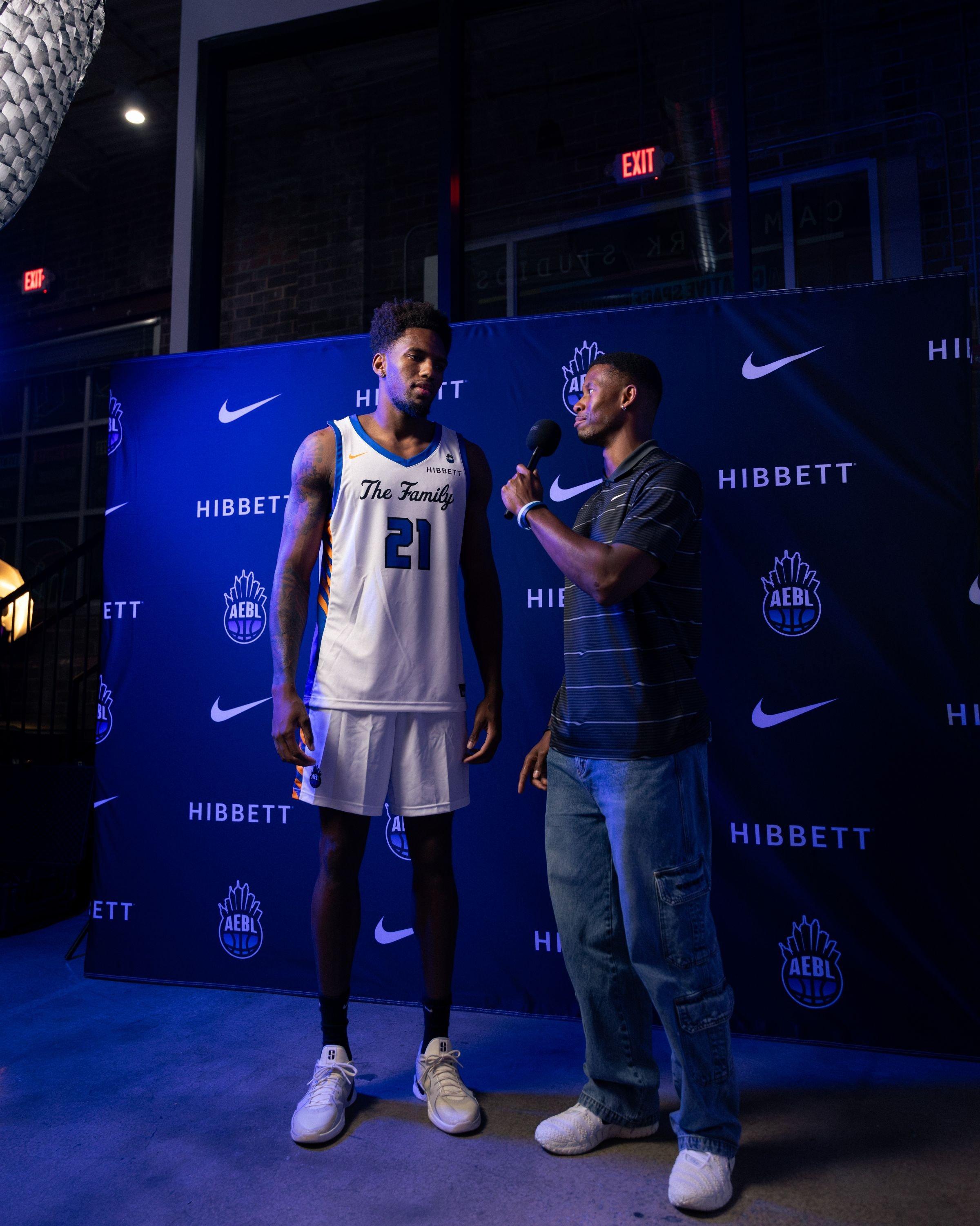 Basketball player being interviewed in front of a Hibbett, Nike and AEBL event backdrop.