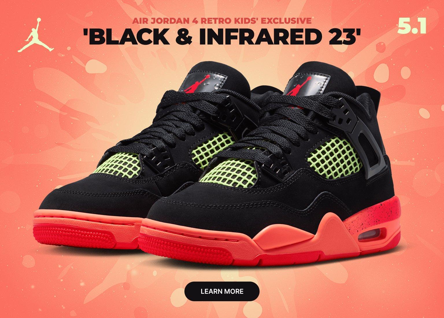 A wide promotional banner for the Air Jordan 4 Retro Kids' Exclusive 'Black & Infrared 23'. Two identical sneakers face each other against a vibrant orange and red splash background. The shoes feature black nubuck uppers, lime green mesh, and speckled infrared midsoles. A Jumpman logo appears in the top left, with a Learn More button at the bottom center.