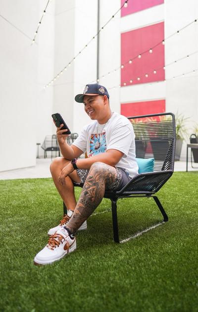Alex Walter posing in outdoor chair on patio