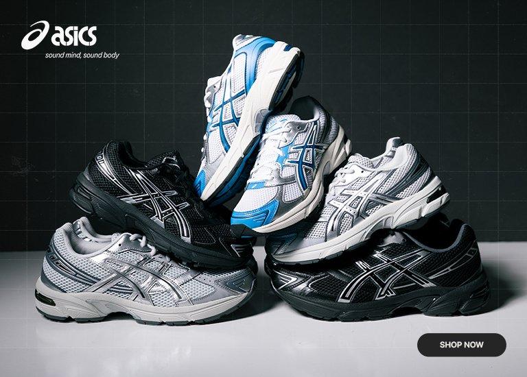 Group of ASICS running shoes in black, white, silver, and blue colorways displayed on a reflective surface, highlighting multiple sneaker styles from the collection.