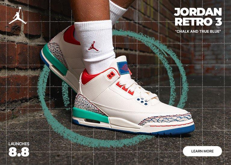 Kids' Jordan Retro 3 "Chalk and True Blue" sneakers with matching apparel against an urban brick wall backdrop.