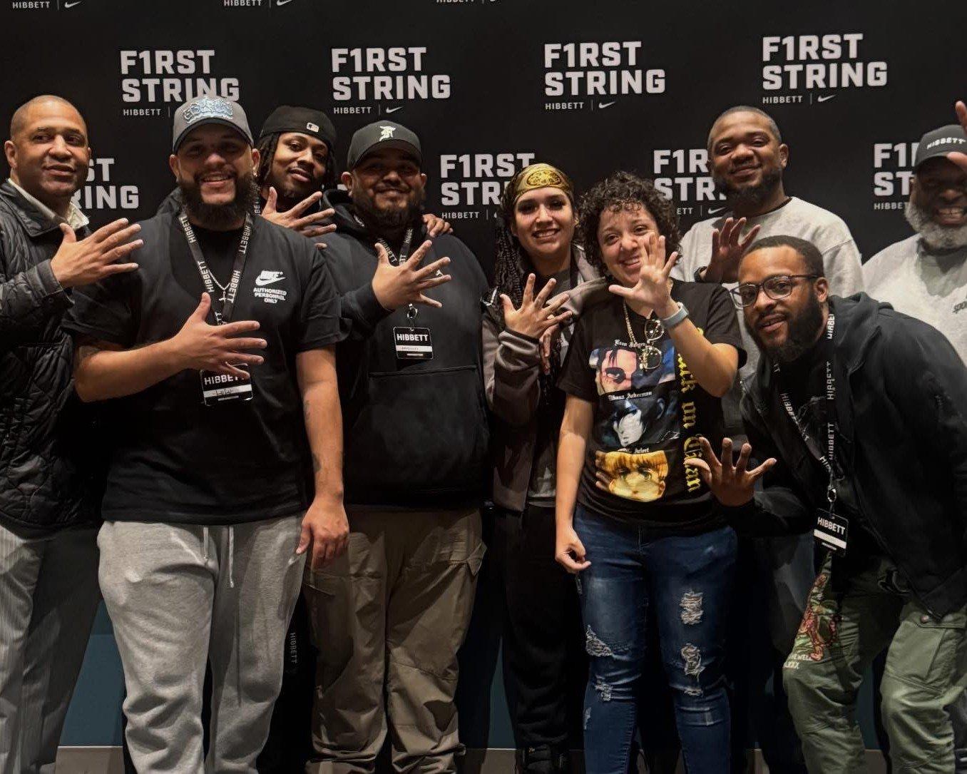 group of adults holding up five fingers