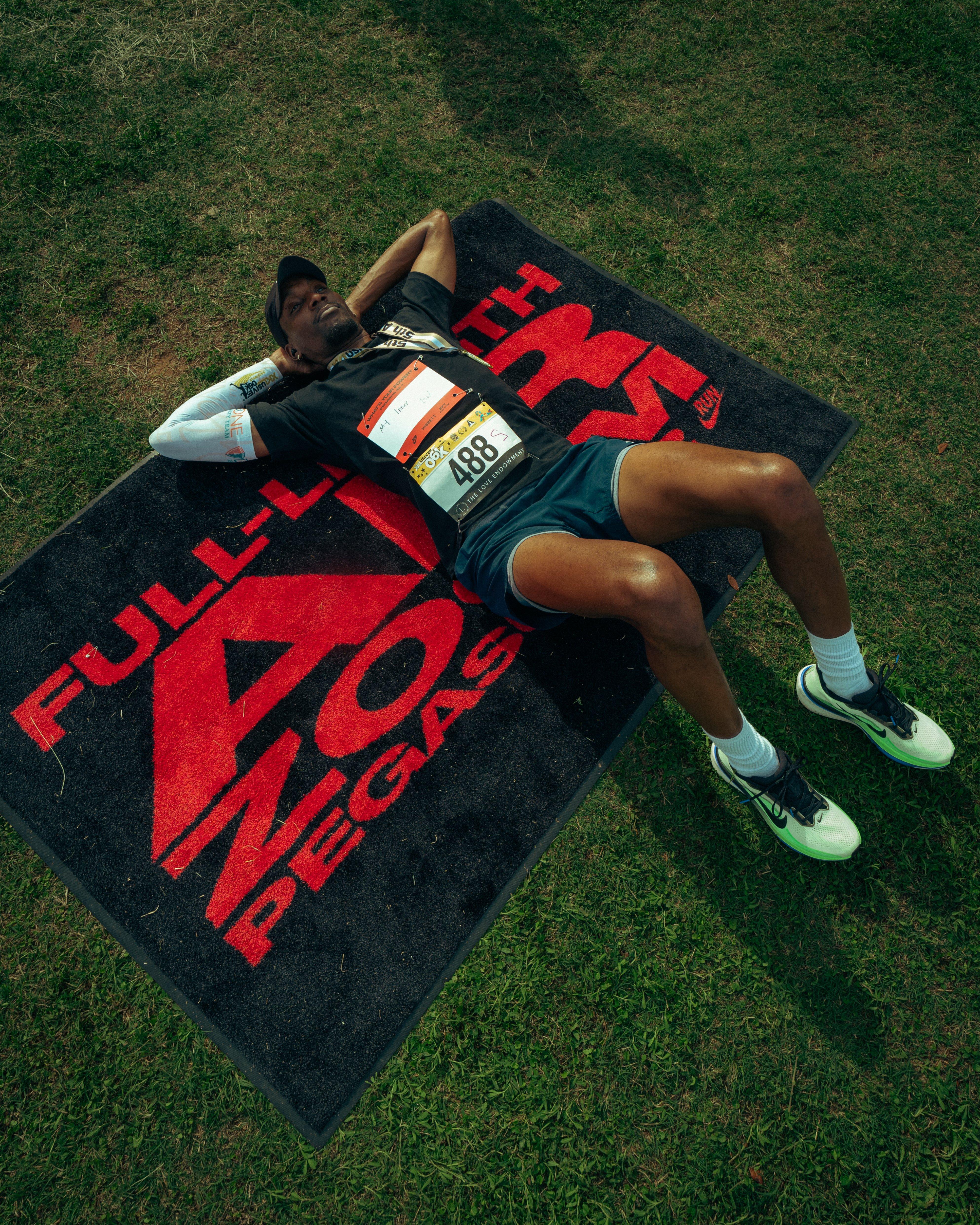 Man laying on ground under black and red rug