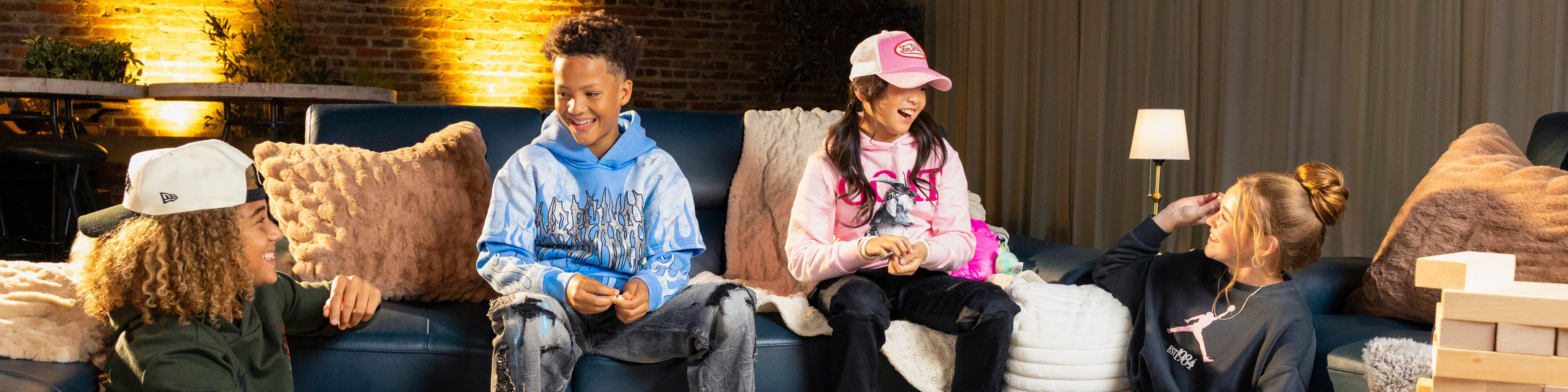 2 boys and 2 girls seated on and around a couch