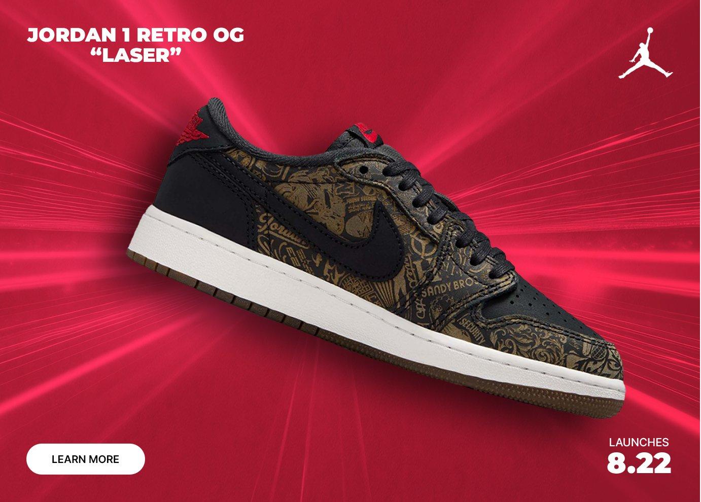 Jordan 1 Retro OG Laser low-top sneaker featuring black leather overlays, engraved gold laser artwork, black Swoosh, white midsole, and gum outsole on a vibrant red promotional background with launch date August 22.