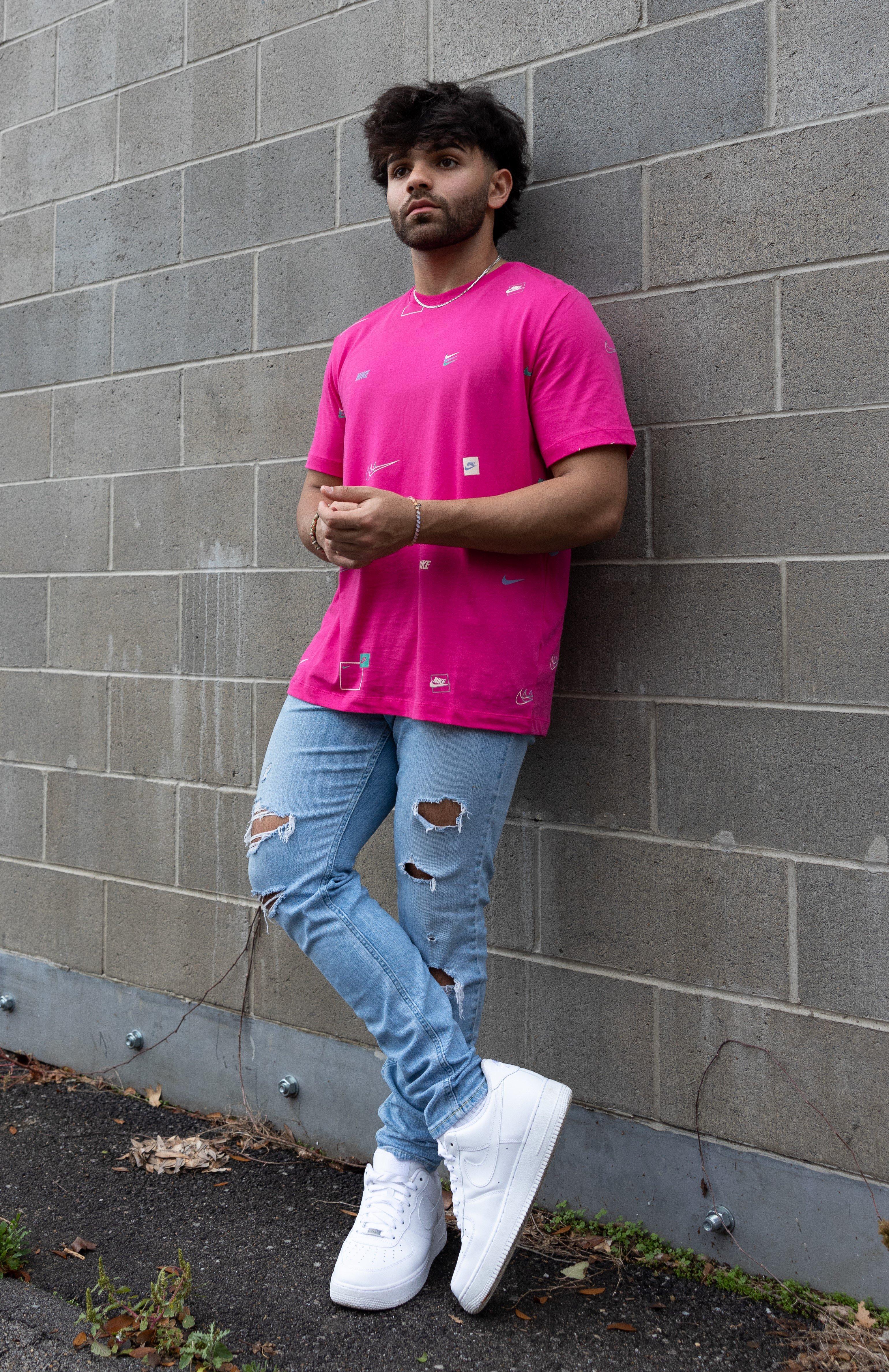 Nike Men's AOP Tee in Magenta, paired with distressed lightwash denim jeans and white/white Nike AF1s