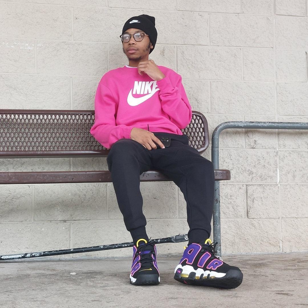 Men's magenta-colored fleece crewneck sweatshirt, black Nike joggers and Nike Air Uptempo sneakers