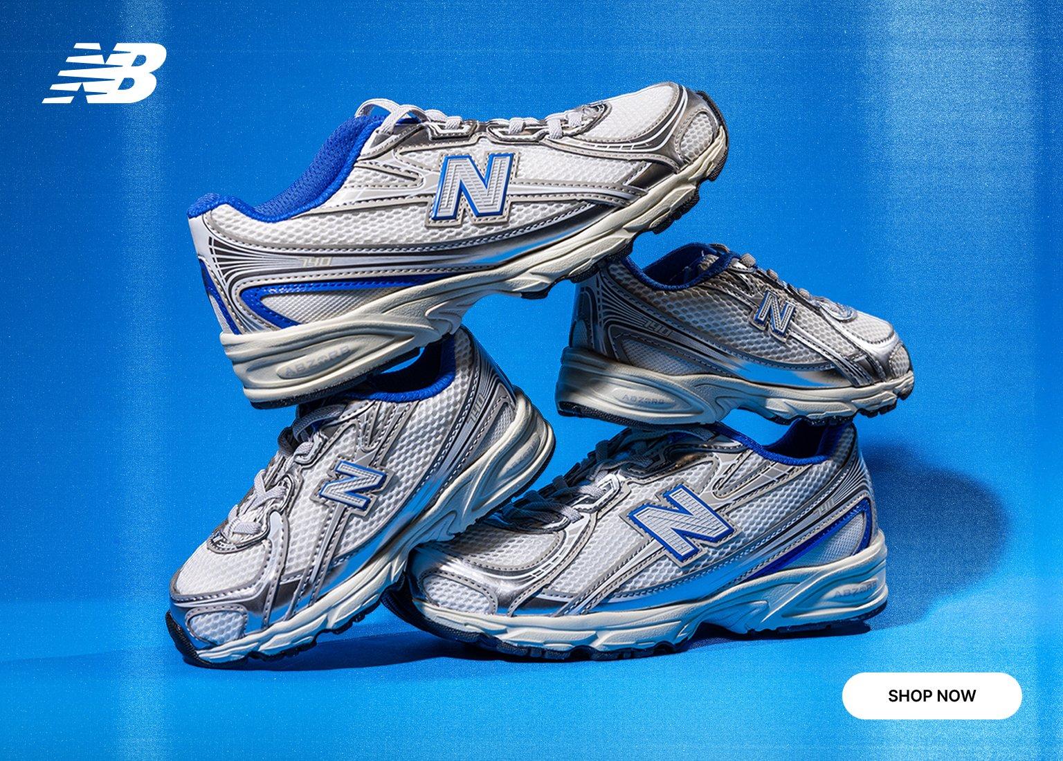 Product banner for New Balance featuring a stack of four New Balance 740 sneakers in a white, silver, and royal blue colorway. The shoes are displayed against a vibrant blue background with a white New Balance logo in the top left and a Shop Now button in the bottom right.