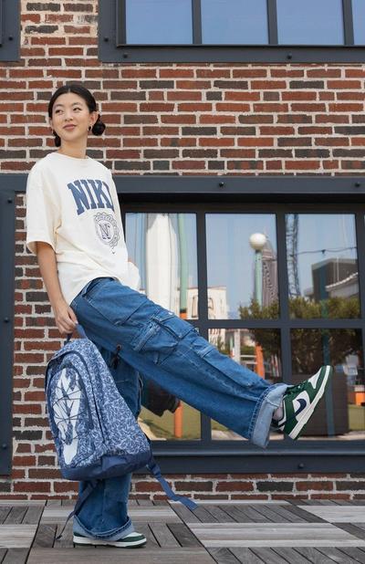 Model wearing Y2K style jeans and oversized Nike tee with Nike Dunk Low sneakers