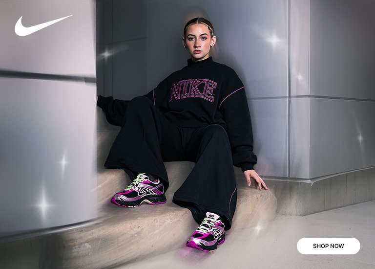 Close-up of a Nike Air Max Moto shoe in black and metallic pink/purple with neon green laces, adjacent to a wider shot of a person wearing the same shoes, black wide-leg pants, and a black sweatshirt with a pink NIKE logo.