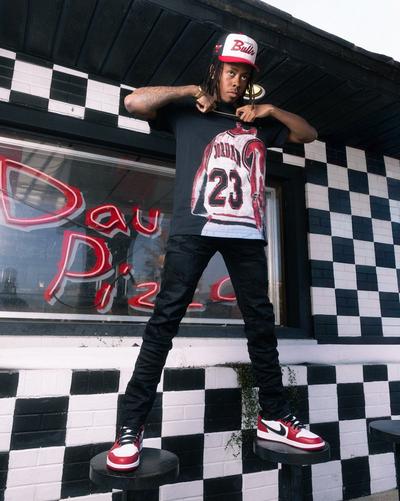 Young man in dark Jordan apparel and low top Jordan 1 sneakers