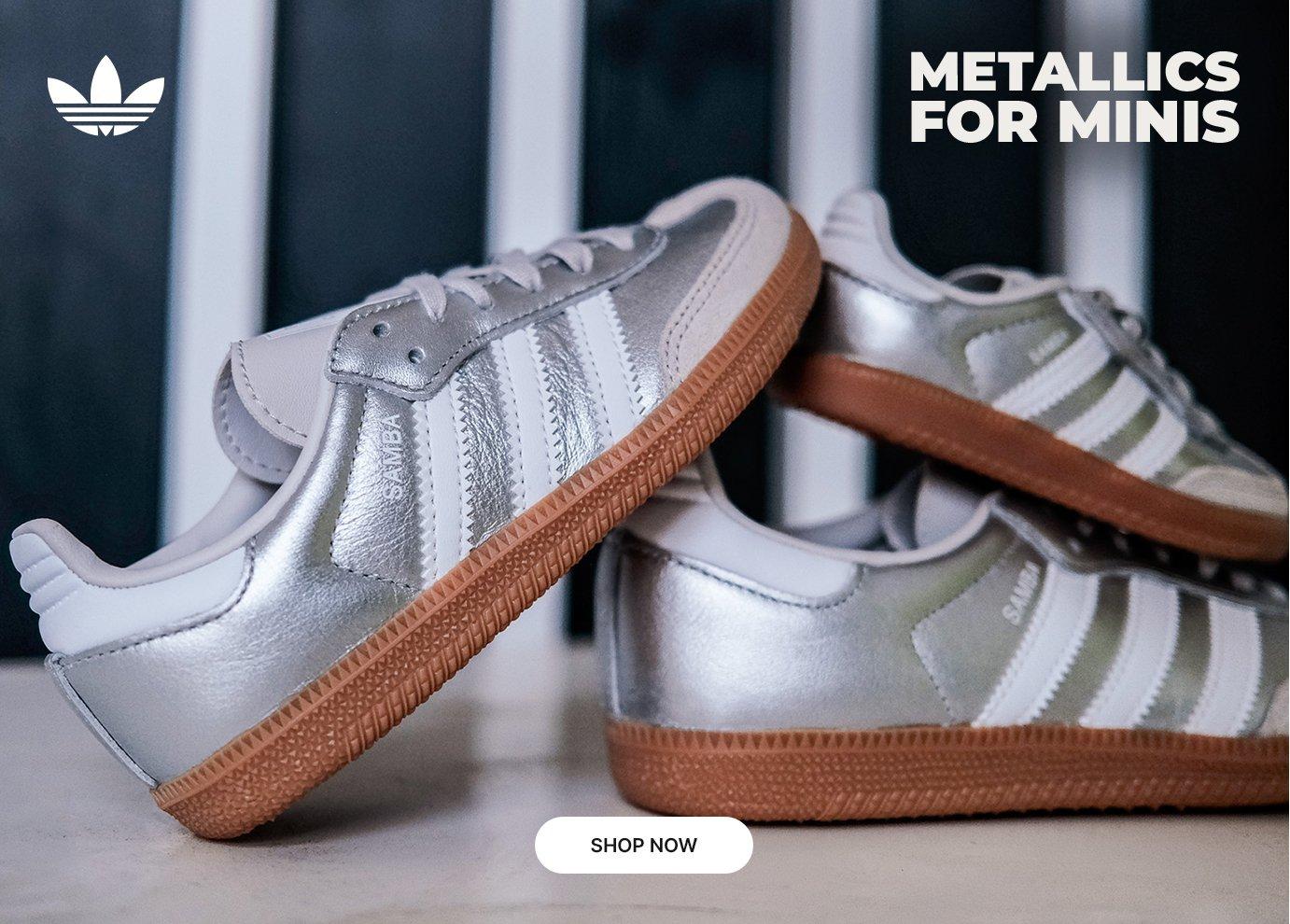 adidas Samba kids sneakers in metallic silver with white stripes and gum soles.