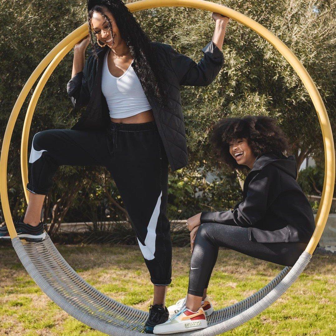Air Chambers and Mychal Bella Bowman posing on a rounded hanging lounge swing