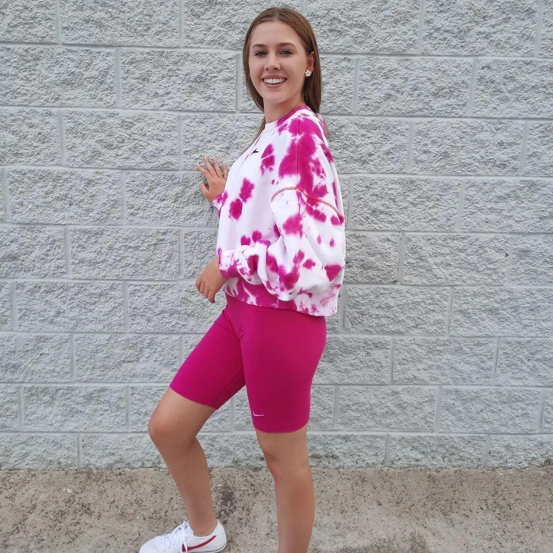Women's magenta Nike biker shorts and pink/white tie-dye fleece sweatshirt