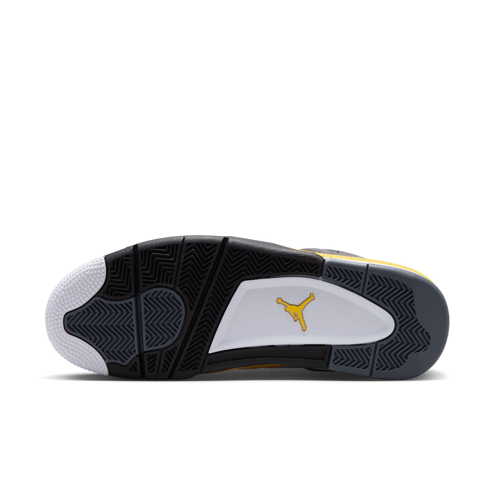 Bottom view of the Air Jordan 4 Tour Yellow sneaker showing a black, gray and white traction outsole with a yellow Jumpman logo.