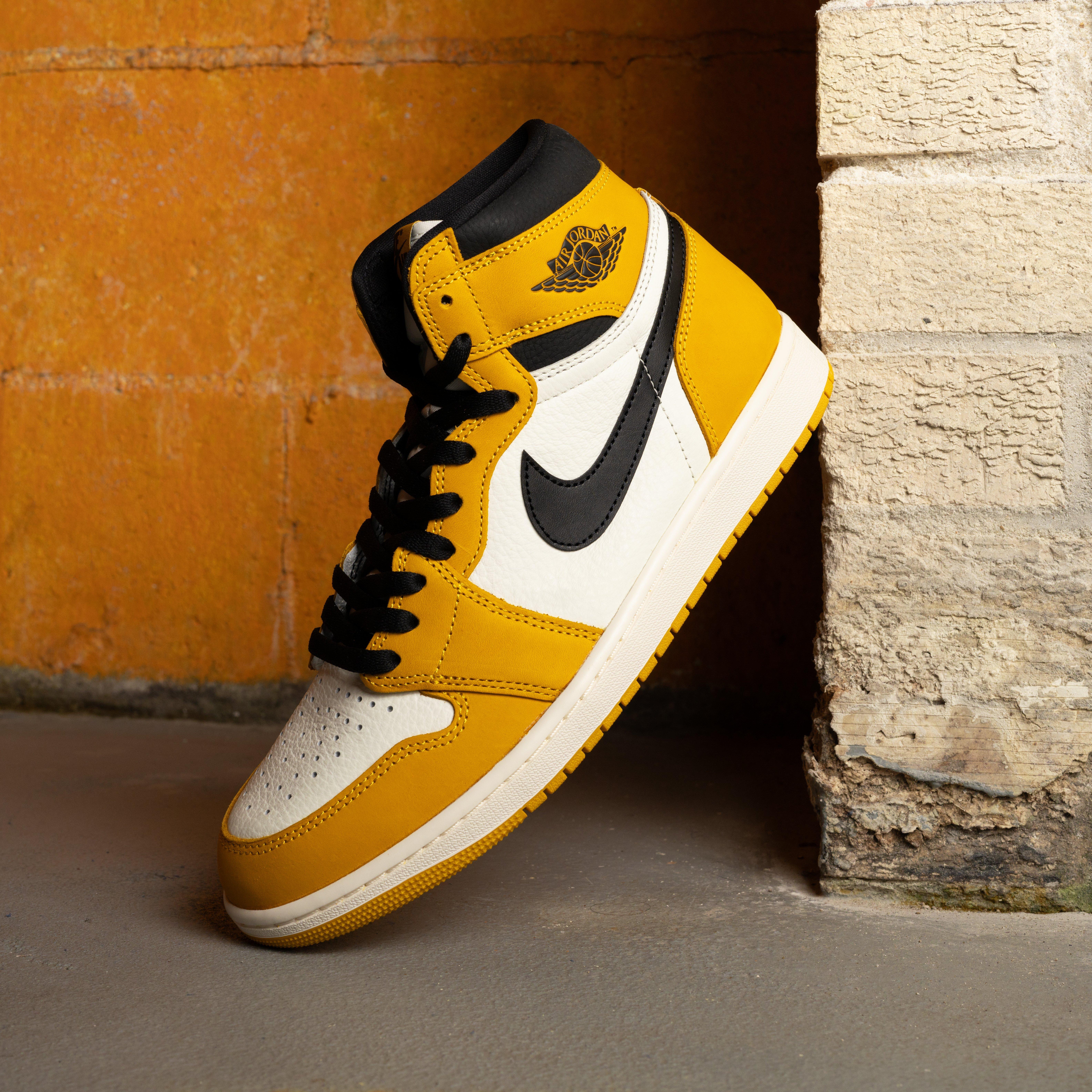 Air Jordan 1 High OG "Yellow Ochre" Left Shoe Against Wall