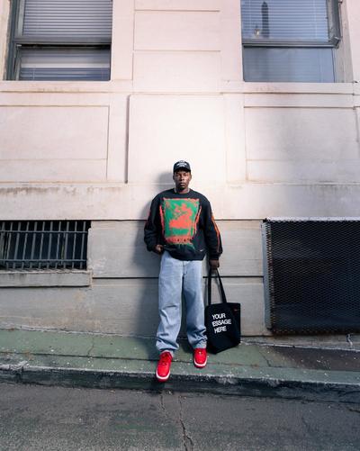Person holding a basketball while wearing a white Nike quarter-zip top over a black athletic top and black Nike basketball shorts.