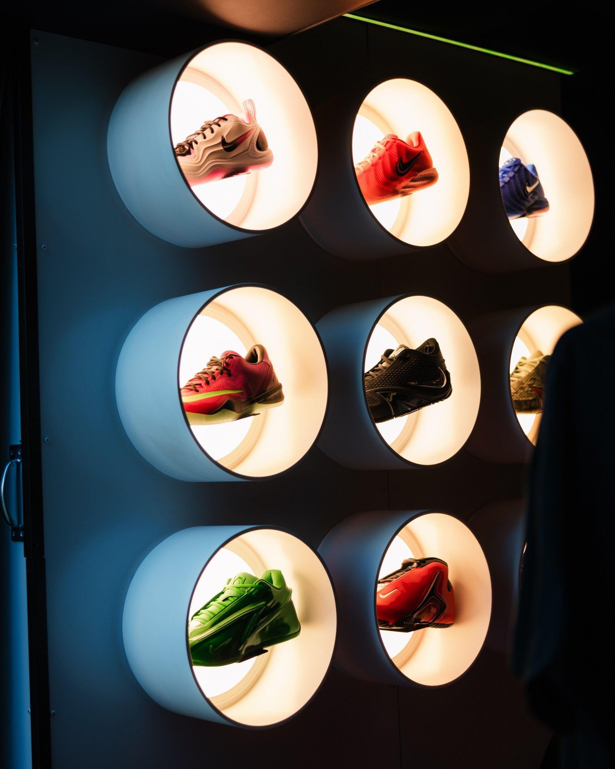 Colorful Nike basketball sneakers displayed inside illuminated circular wall fixtures.