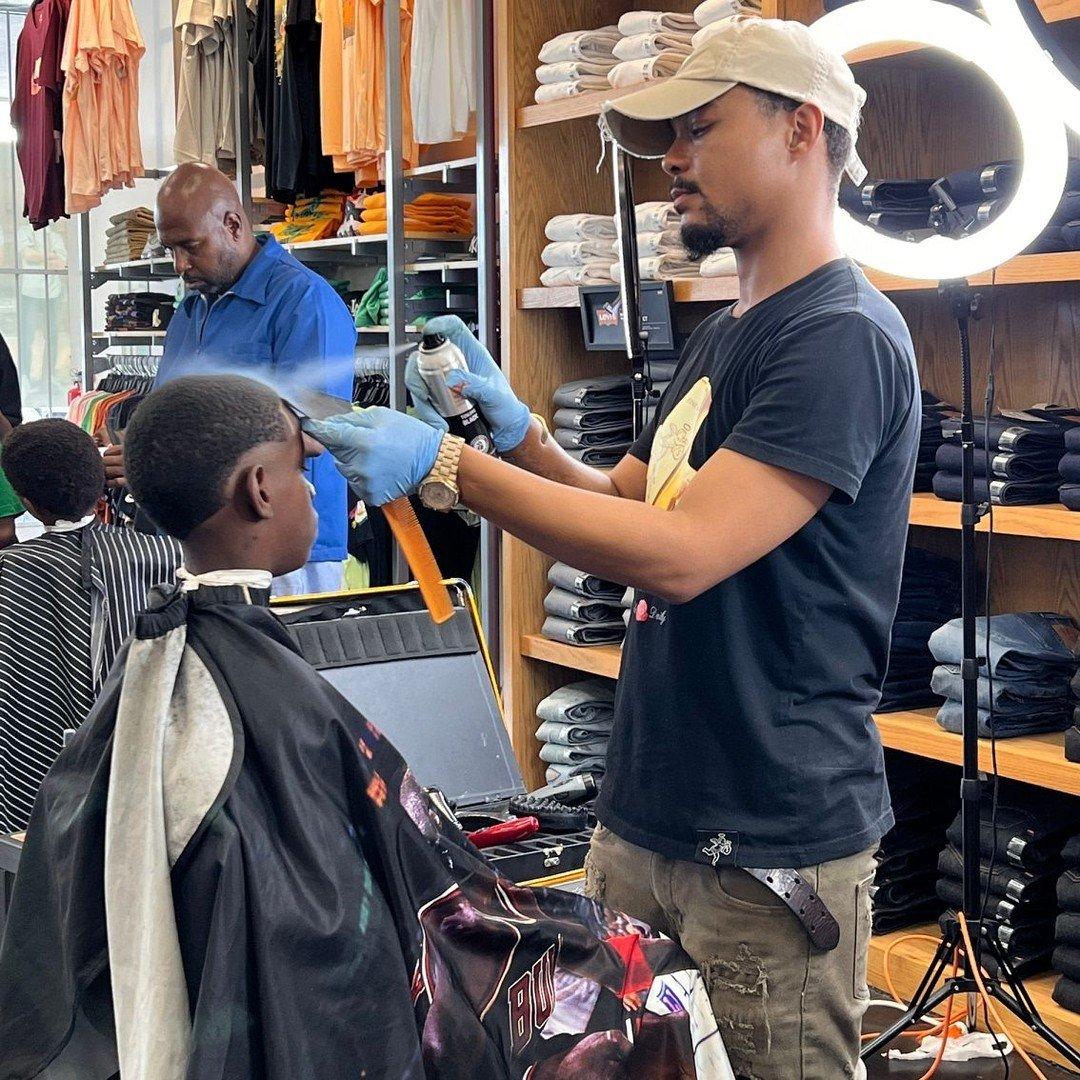 Barber spaying a kids' hair during Jackson, MS Cutz 4 Kids event