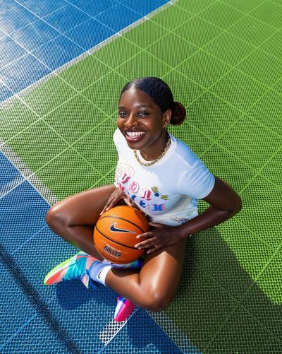 White fitted basketball graphic tee styled on an outdoor court with colorful sneakers