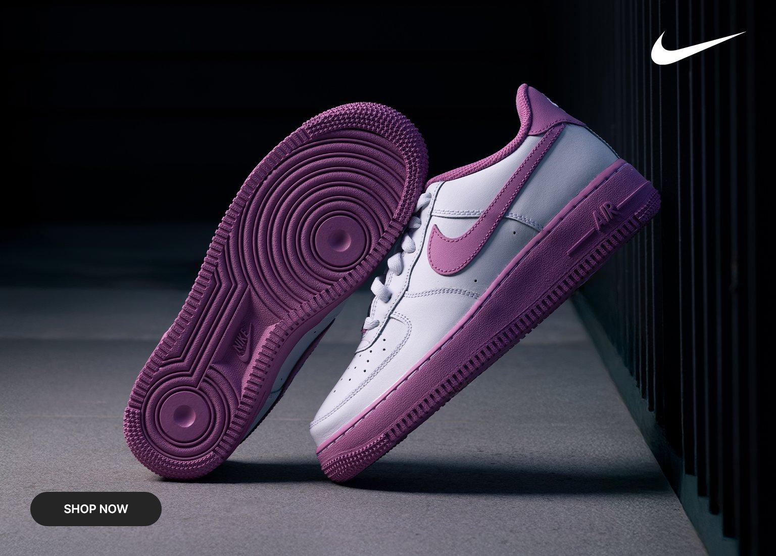 This promotional Nike banner showcases white Air Force 1 sneakers with vibrant pink accents on the soles and swooshes through a split-screen design. The left side displays the full shoe against a dark, moody background, while the right side features a high-detail close-up of the textured leather and stitching.