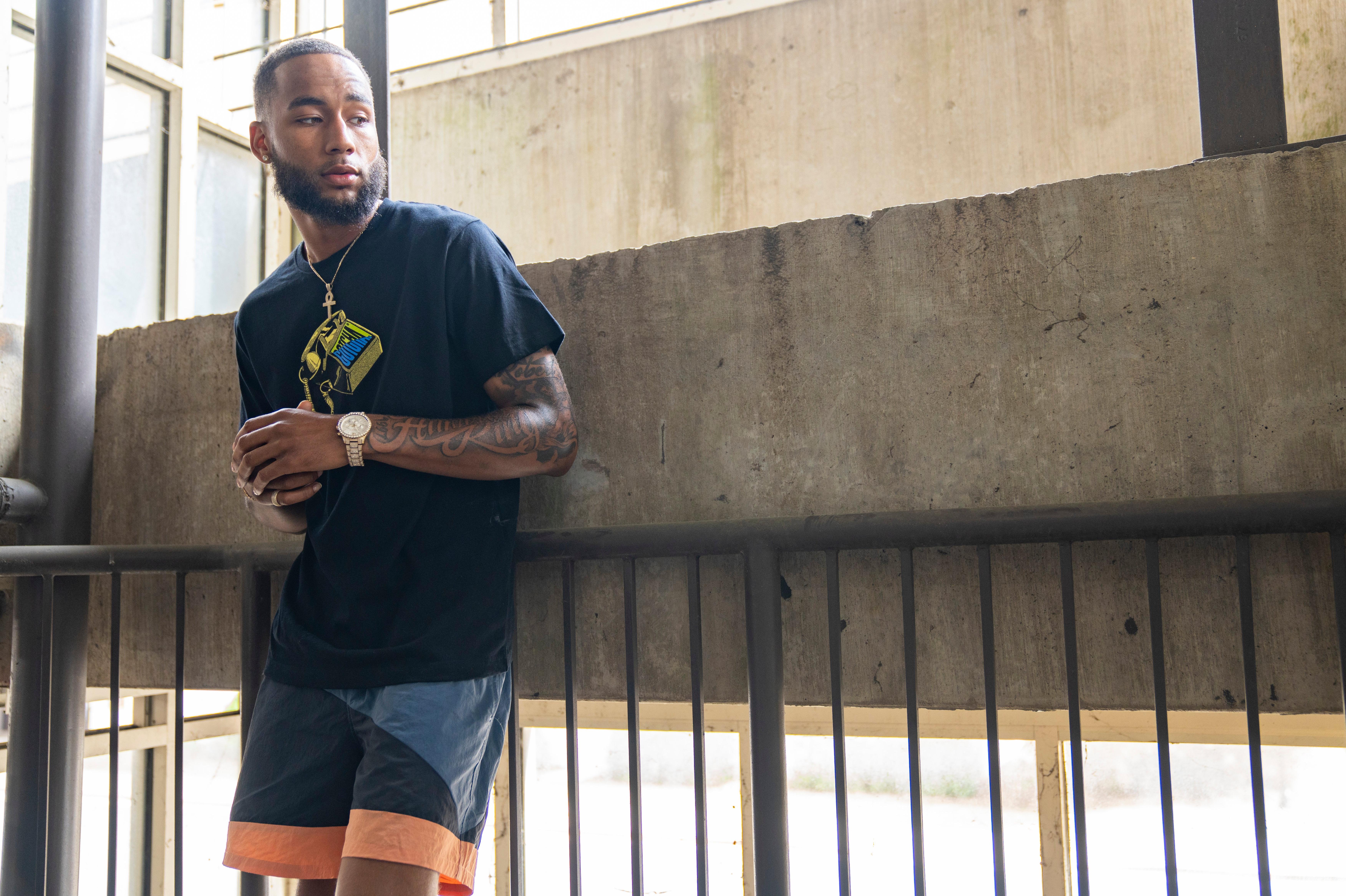 Man Wearing Gotcha Brand graphic tee and nylon shorts